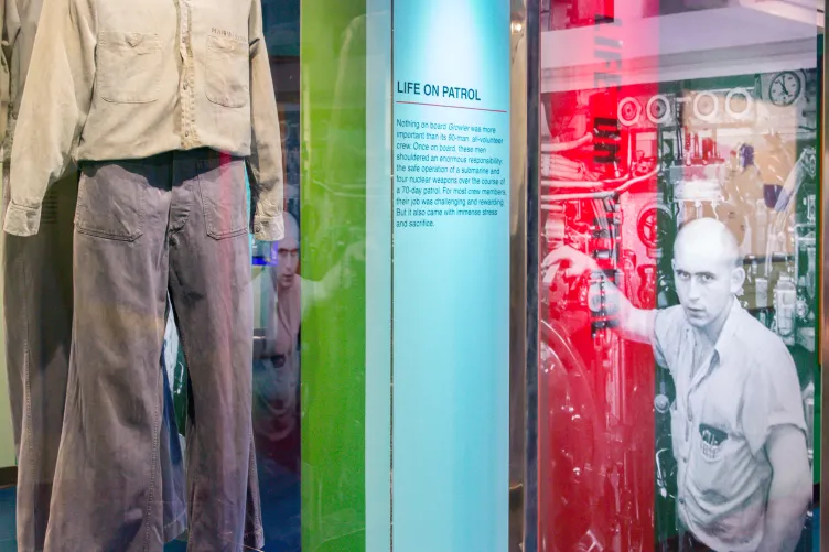 Display case showing a uniform and exhibition panel.