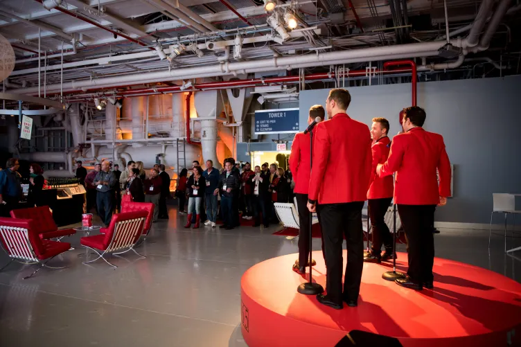 Singers on stage while event attendants enter event venue.