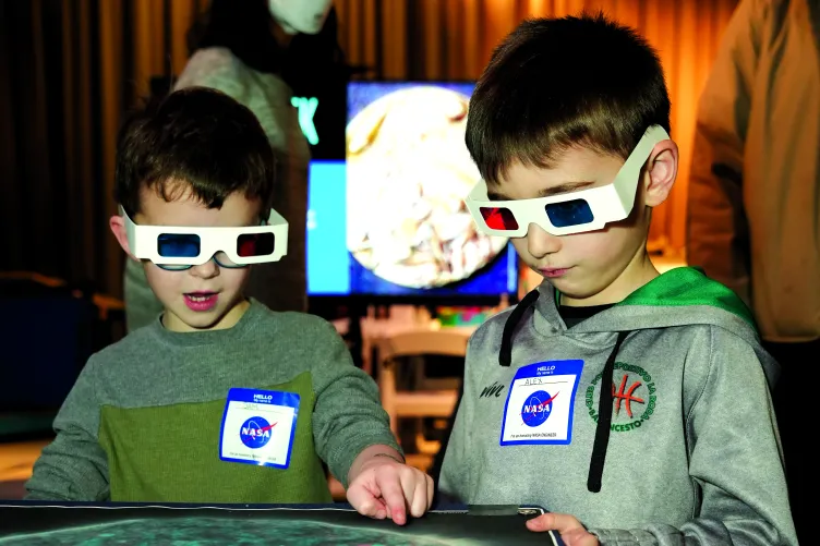 Two children participating in a NASA interactive activity during Kids Week.