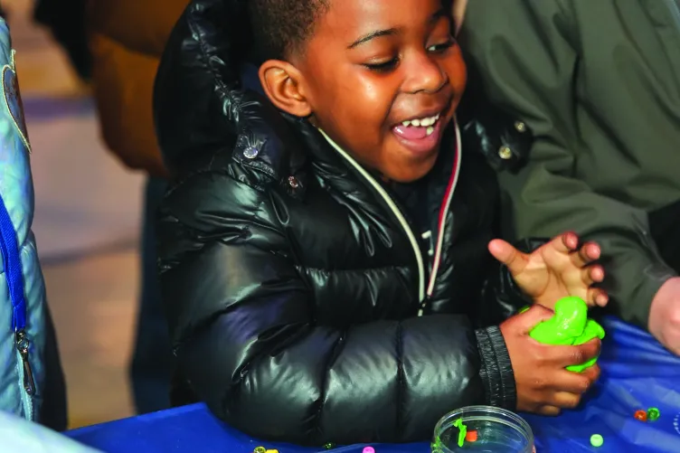 A young boy engaging in an interactive activity during Kids Week.