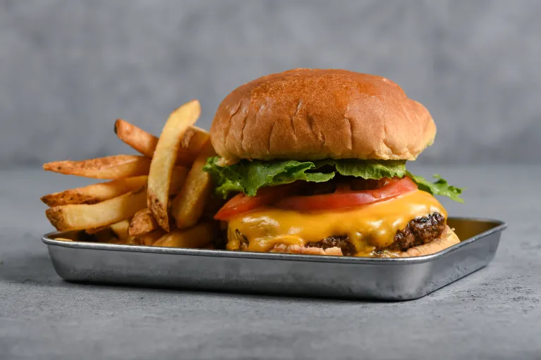 A  cheeseburger and fries on a tray