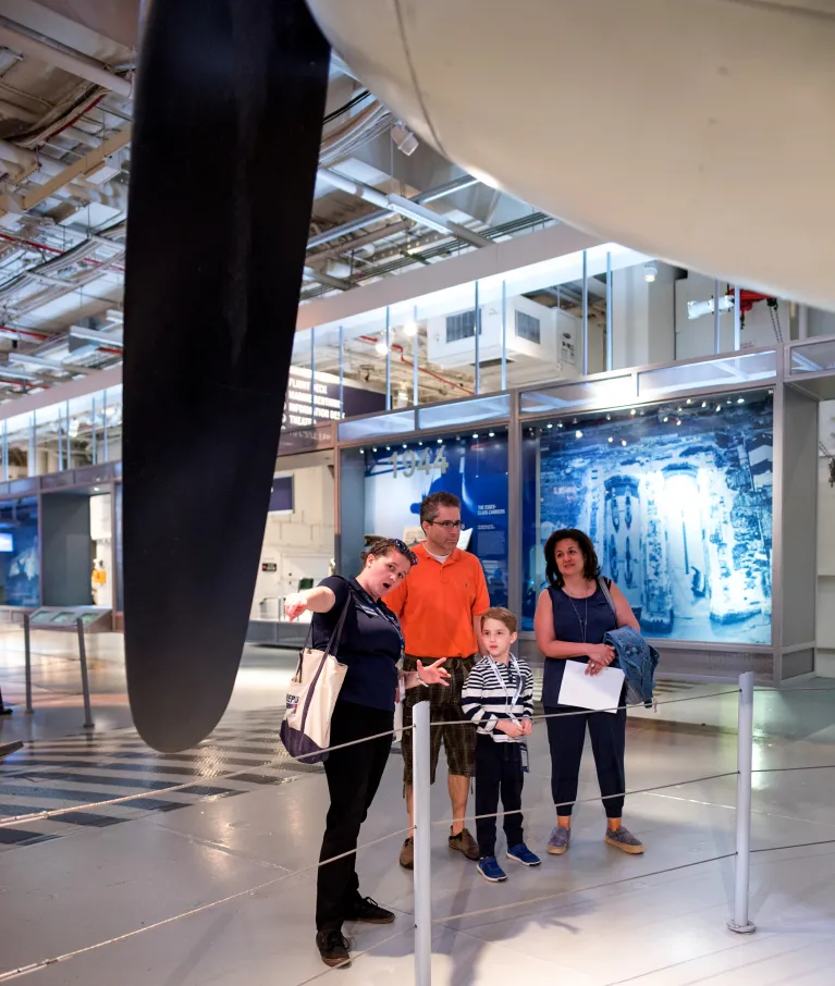 A family with a Museum educator looking at an airplane