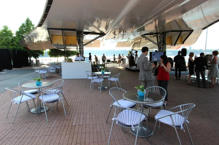 Round tables and chairs set up beneath the Concorde