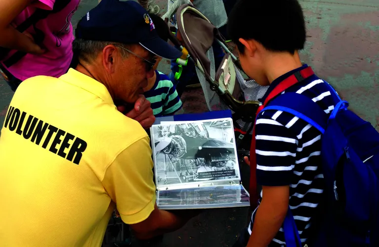 A veterans is speaking with a child at the Museum.