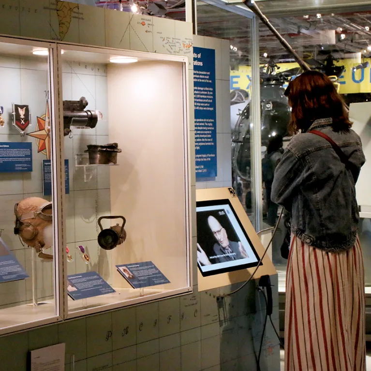 A visitor is listening to the audio component of an exhibition.