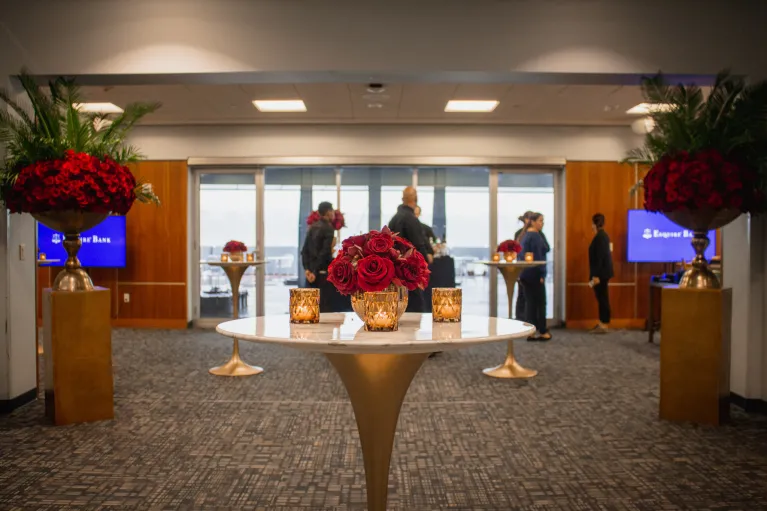 VIP Room set for a cocktail reception with decor and red rose floral arrangements