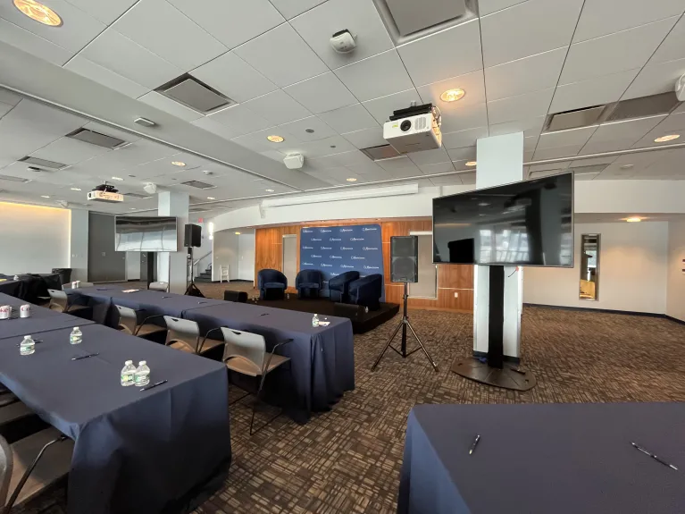 Classroom style seating facing a panel setup in the Great Hall for a conference