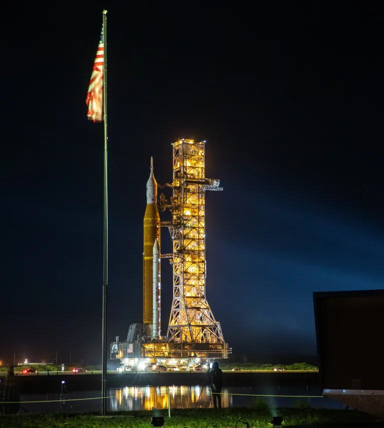 NASA’s Artemis I Moon rocket – carried atop the crawler-transporter 2, next to the American Flag