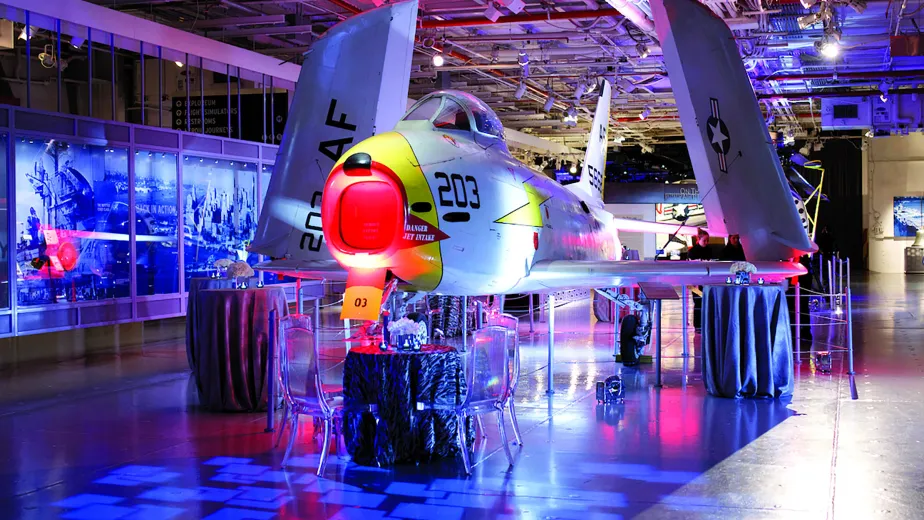 Bistro tables set up for an event on the hangar deck