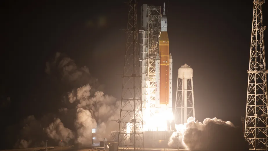 A rocket beginning to launch, surrounded by smoke.